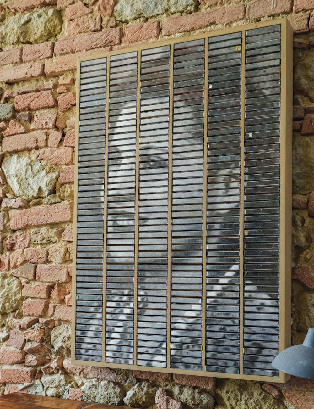 Artwork mounted on a brick wall at Villa Lena, Tuscany
