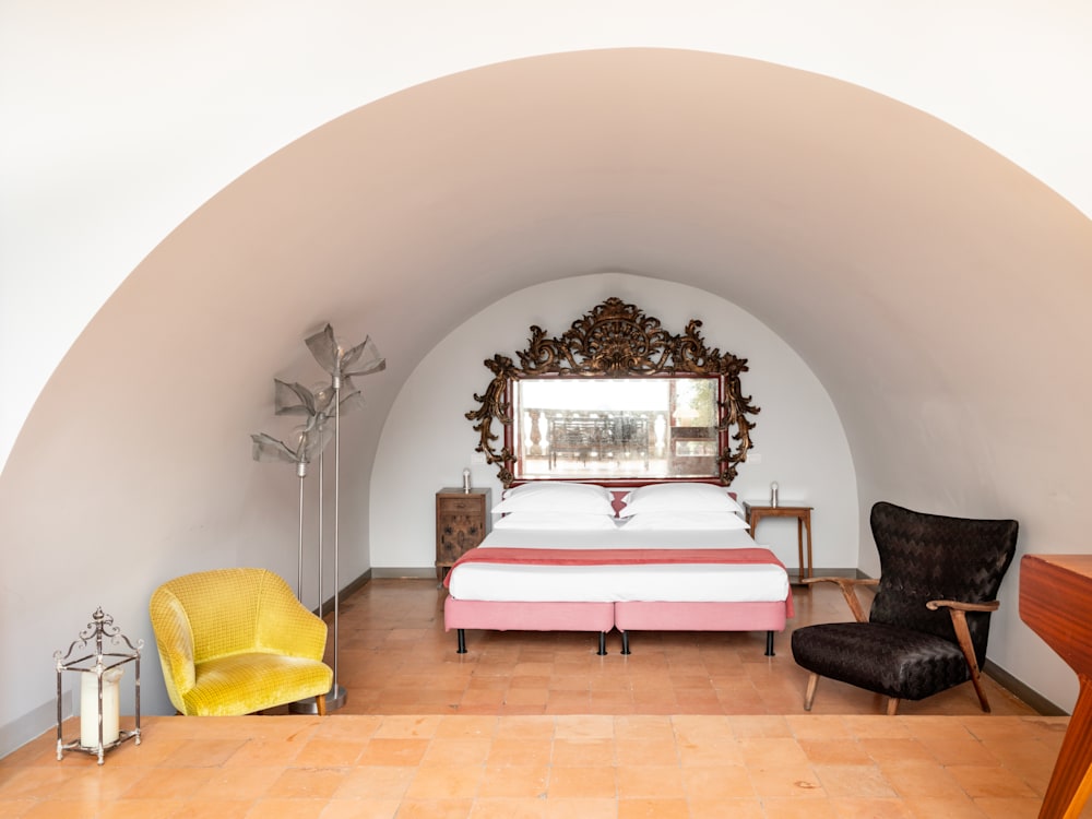 A pink bed and a yellow chair, within a cave like structure