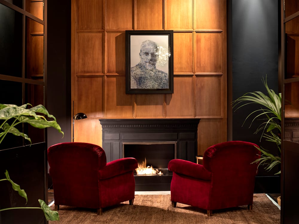 Lounge with velvet chairs and artwork on a panelled wall
