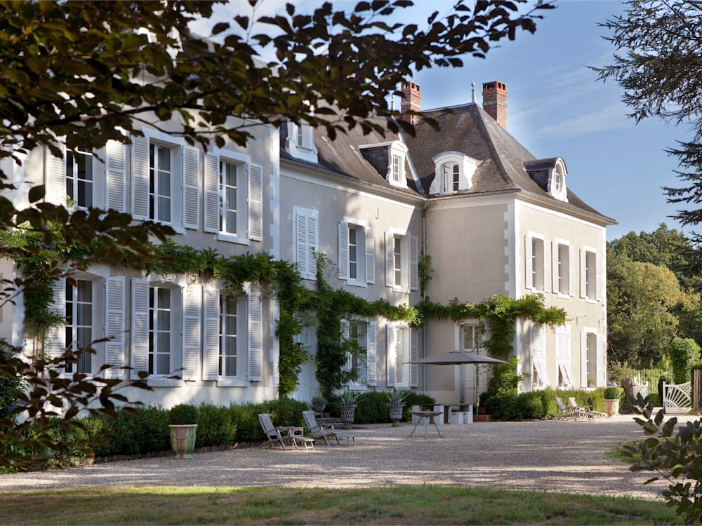 Chateau in the dappled sunlight peeking through the trees.