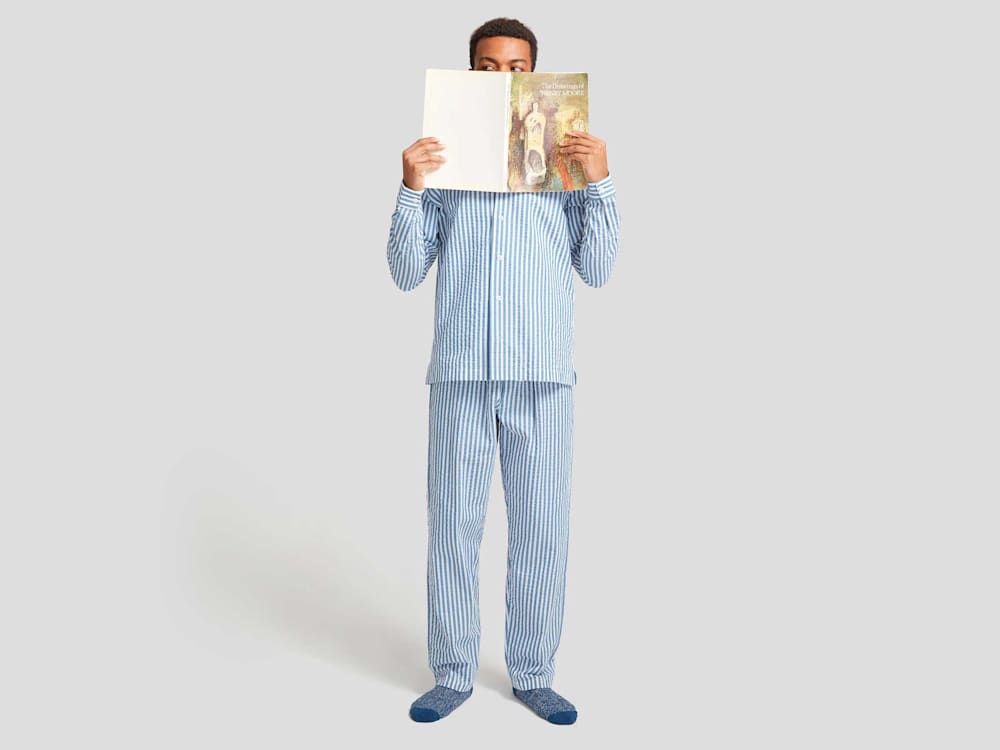 Man in pyjamas reading a book