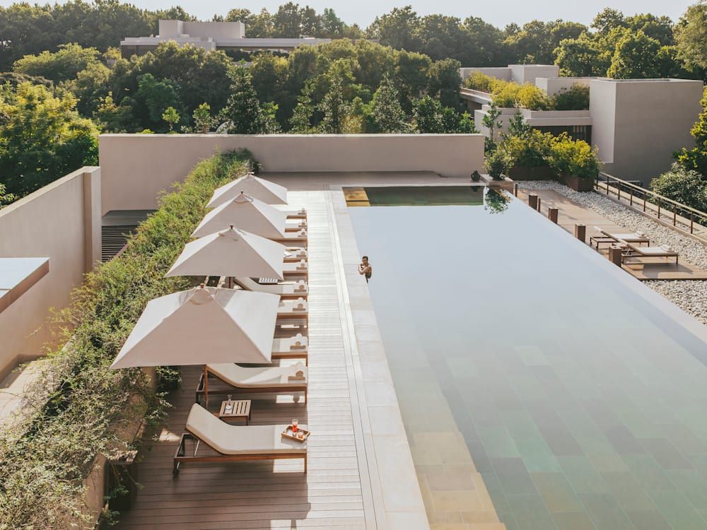 Woman relaxes in rooftop pool in luxury hotel in India