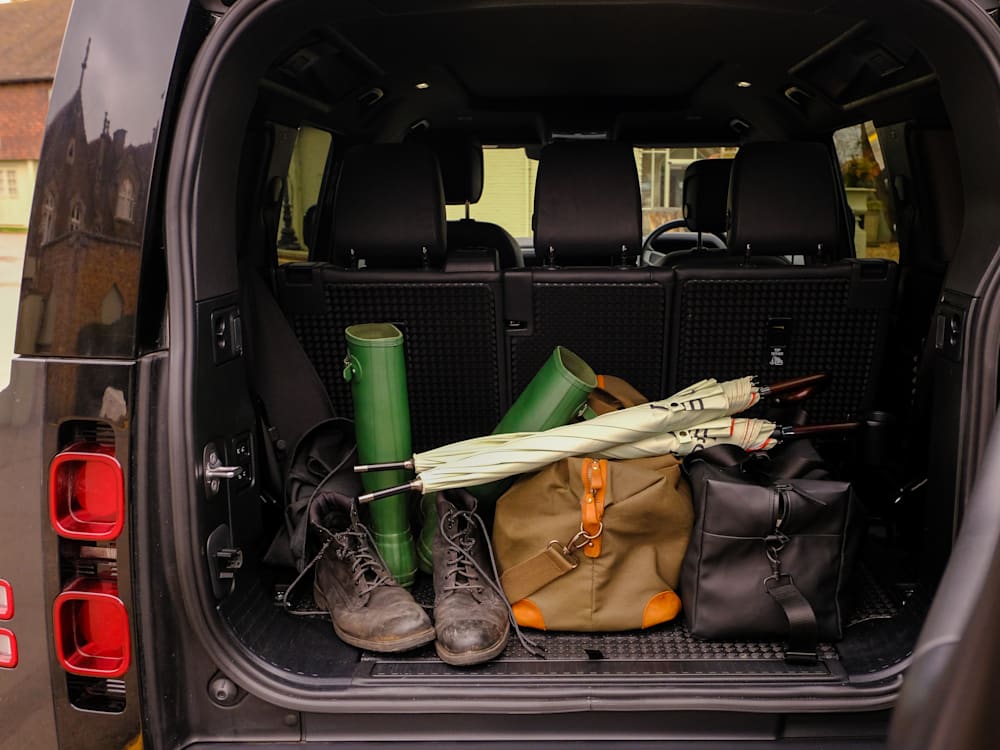 Luggage in the back of a Landrover Defender with wellies and boots
