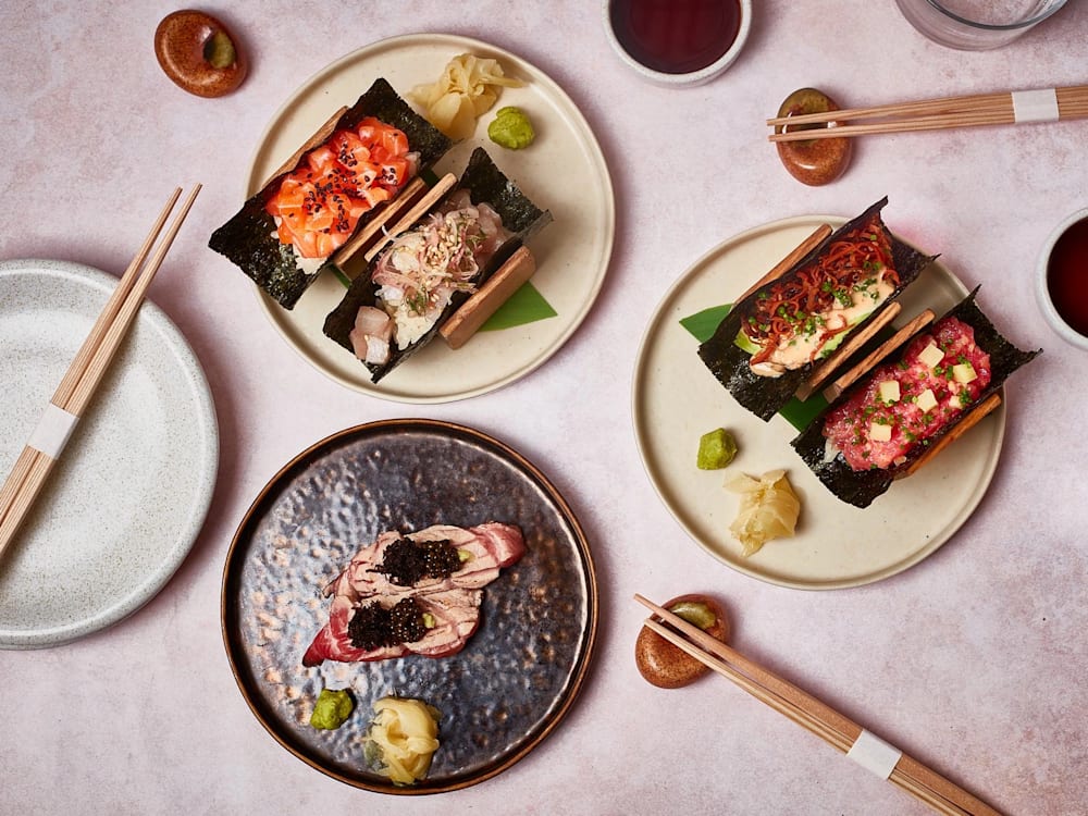 Sushi with chopsticks and various plates with different Japanese dishes