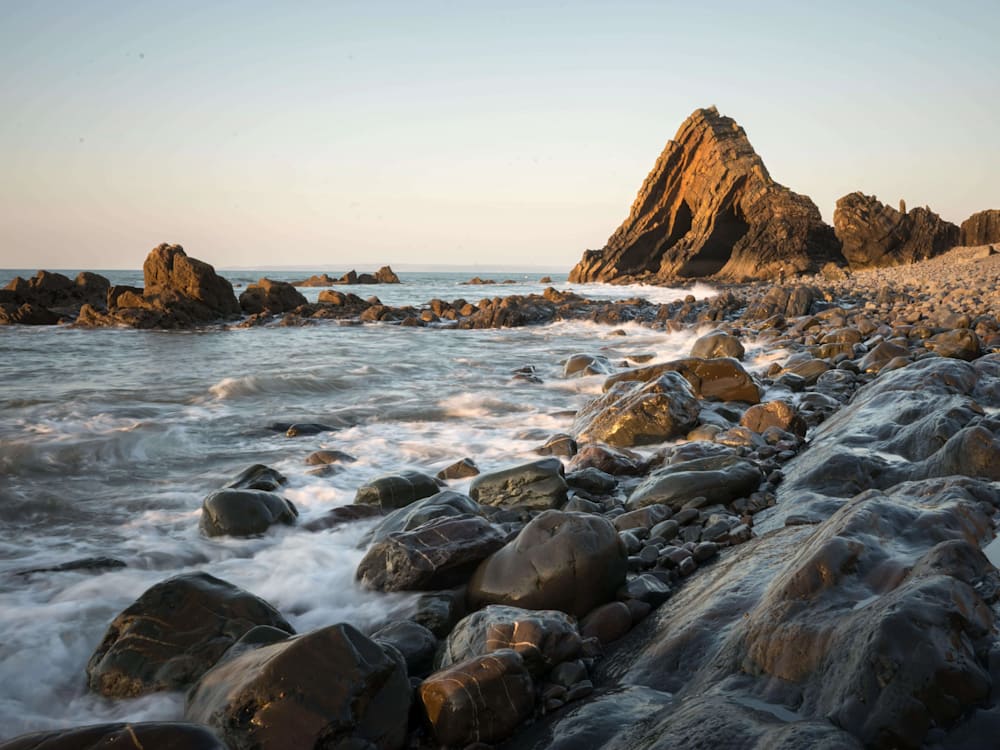 Rocky beach with large triangle shaped rock in Cornwall