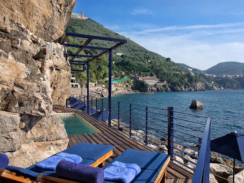 Sun loungers and private swimming pool on private terrace looking over the ocean